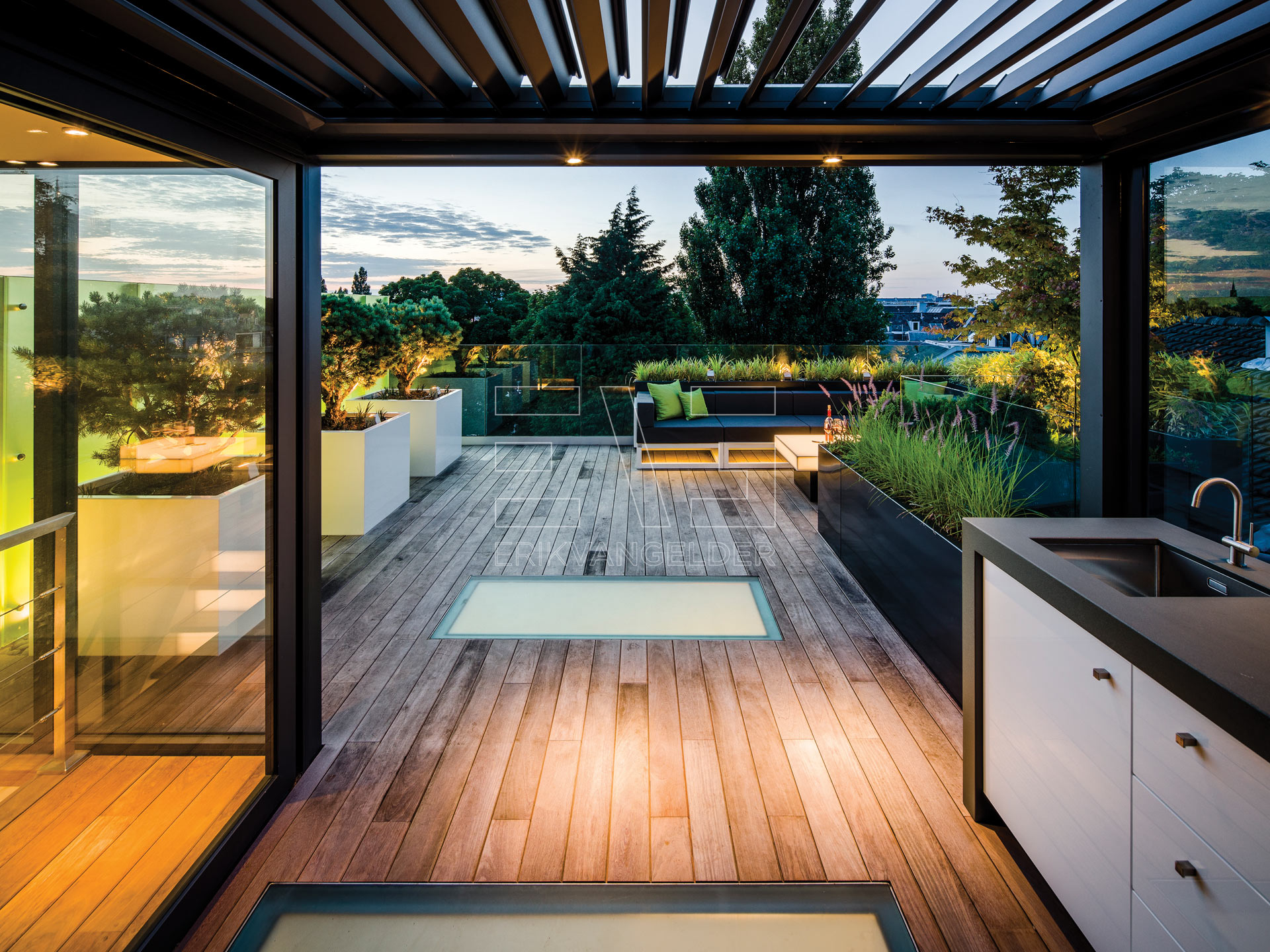 Luxe daktuin roof garden met moderne zwarte overkapping lamellendak buitenkeuken erikvangelder tuindesign exlusive garden sfeervol